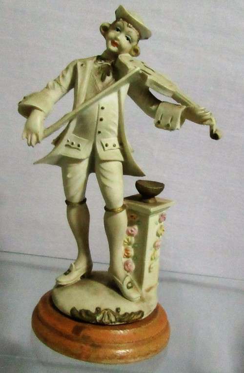 A DELIGHTFUL ITALIAN FIGURINE MOUNTED ON WOOD OF A MAN PLAYING THE VILON