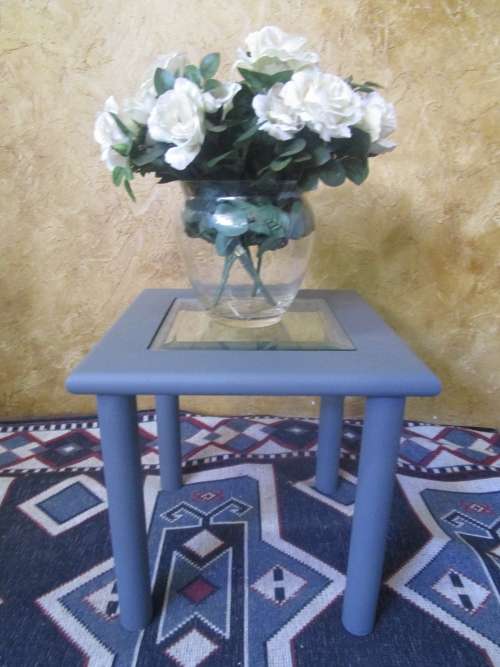 A stunning square chalk painted side table with a glass top