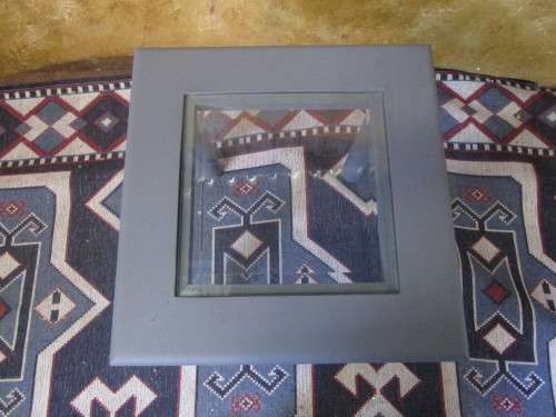 A stunning square chalk painted side table with a glass top