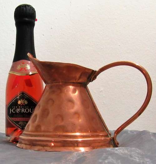 This is a beautiful, shiny copper jug. The jug has a lovely large curved handle