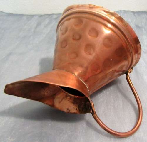 This is a beautiful, shiny copper jug. The jug has a lovely large curved handle