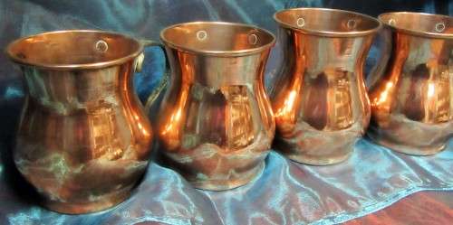 Four attractive antique tin-lined half pint copper mug or tankard with a brass handle.