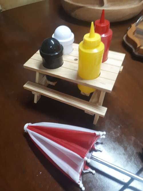 Wooden Table With Umbrella Plastic Condiment Set Plus Two Sauce Bottles