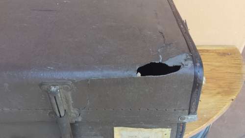 Very old brown expandable suitcase.