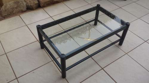 Black metal coffee table with glass top.