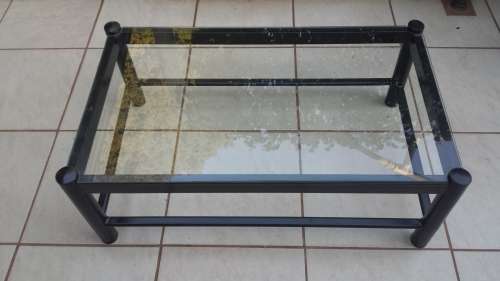 Black metal coffee table with glass top.