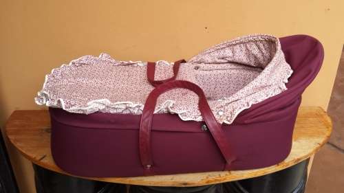 Old maroon baby carry cot.