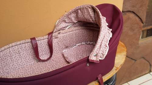 Old maroon baby carry cot.