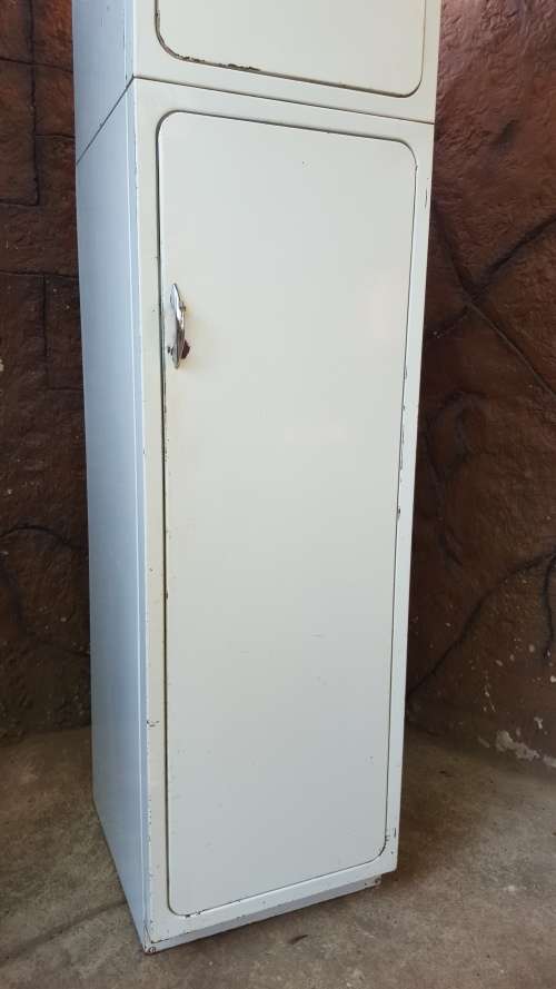 Tall old metal broom cupboard.