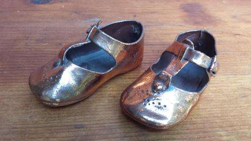 Pair of old copperized childs shoes.