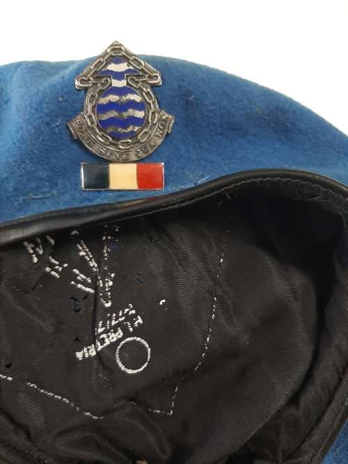 Old blue military beret with badges