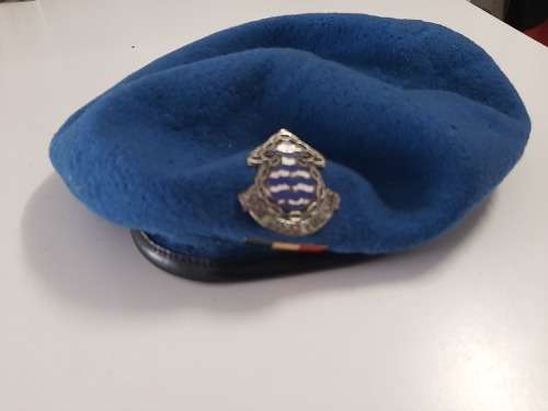 Old blue military beret with badges