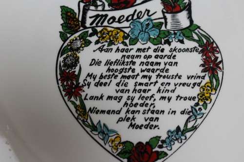 A decorative plate with a dedication written in Afrikaans to a Mother