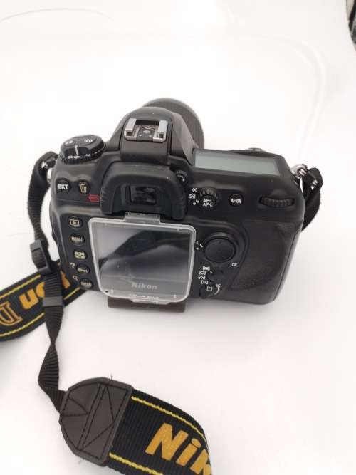 NIKON D2000 CAMERA WORKING COMPLETE WITH CHARGER AND LENSE PLEASE NOTE THE BATTERY COVER IS LOSE!!!