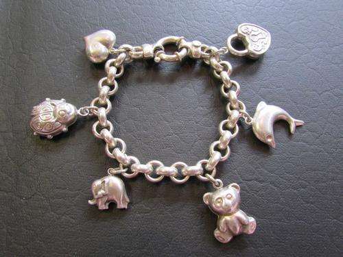 A CHUNKY STERLING SILVER CHARM BRACELET WITH BUBBLE CHARMS