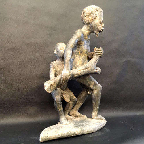 Stone Sculpture of Father and son carrying a tree