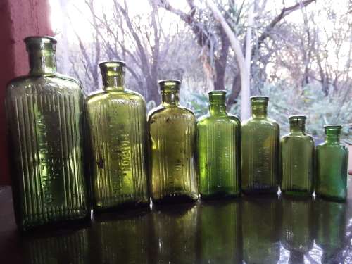 Seven green POISON NOT TO BE TAKEN bottles