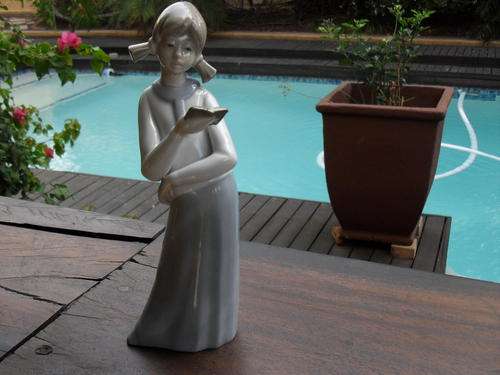 A beautiful LLADRO Style porcelain figurine of a young girl reading a book