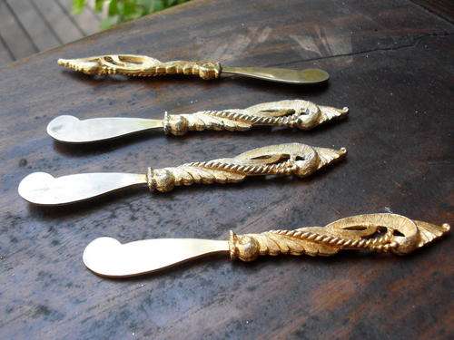 SET OF FOUR VERY UNUSUAL BUTTER KNIVES MARKED C OR O THEN TAN. COULD BE OLD????