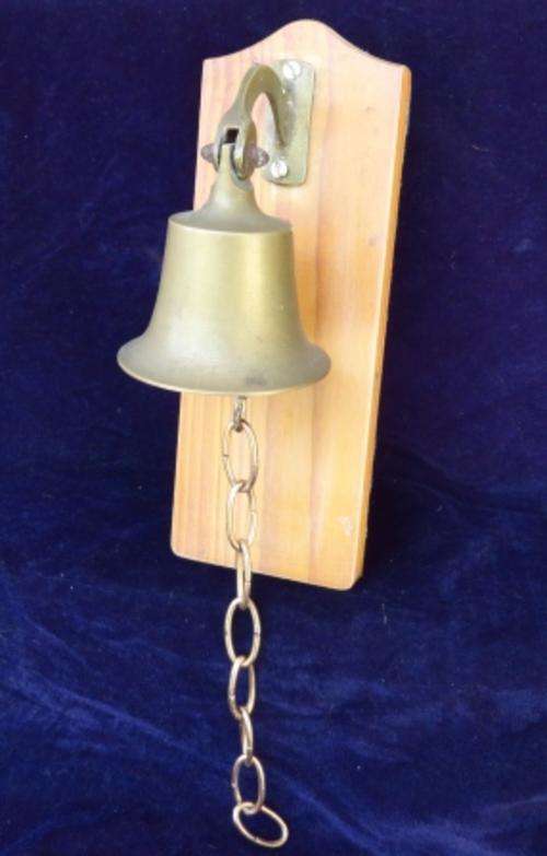 Brass bell on pine wooden stand for auction
