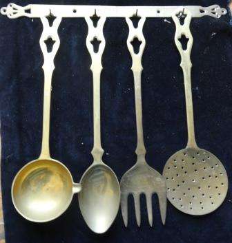A collection of solid BRASS kitchen utensils with decorated brass holder