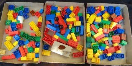 A massive collection of lego pieces as set out in three beer vtrays.