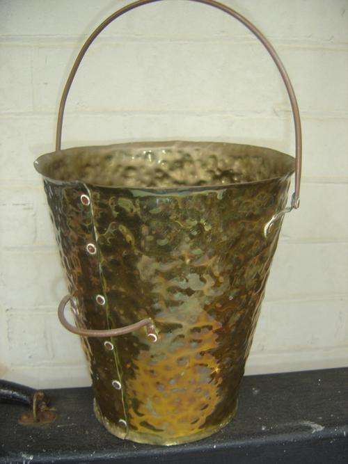 Vintage mottled brass pail with a copper handle .