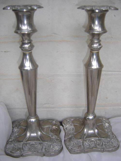 A pair of electoplated and decorated candlesticks for auction.