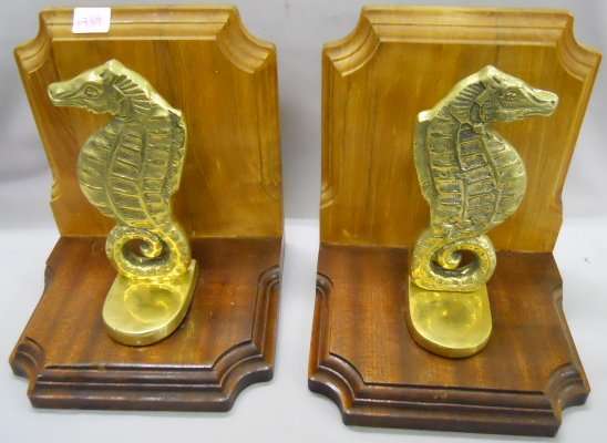 A pair of brass Seahorse BOOKENDS, on wooden L-shaped brackets, 22cm high