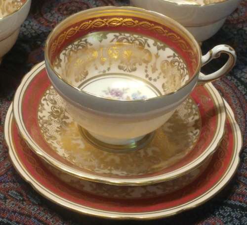 Elegant Royal Paragon floral sprig gold, pink and a maroon band Rococo-style Tea trio 1952-1956