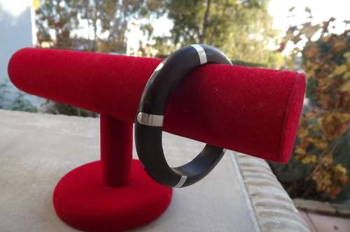 Unique dark wooden bangle with metal inlays Diam. 6.6cm. Good condition