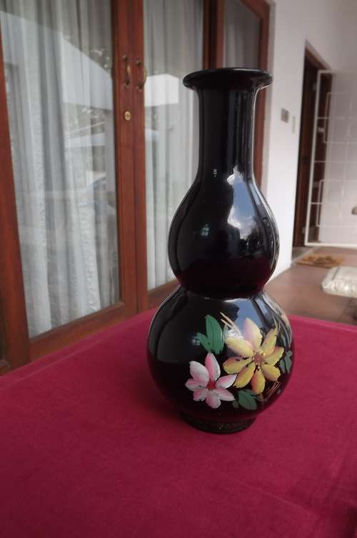 Black porcelain vase with handpainted flower decoration on front.Height 22cm.Good condition