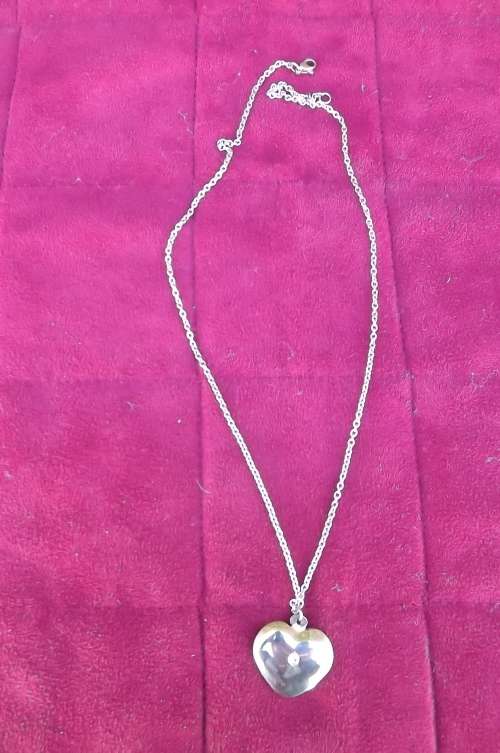Silver toned chain wih heart shaped pendant.See scans for detail.New condition