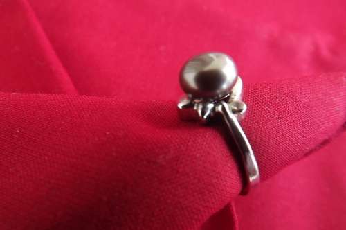 Pretty rhodium plate ring size 7 with genuine pearl in light brown colour.With 2 small zirconias.