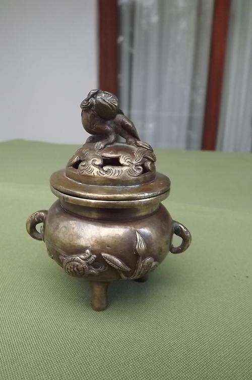 Antique three legged bronze embossed pot with lid.Mythologic animal on top.Height with lid 8cm openi