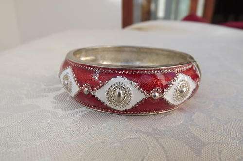 Metal adjustable bangle with red and white enamel decoration.Good condition