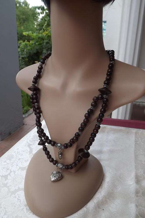 Wooden necklace with hanging metal hearts in as new condition.