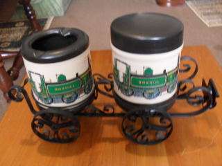2 X LEATHER COVERED JARS ON A COACH STYLE WROUGHT IRON STAND.......