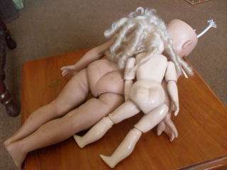 AN ELASTICATED BISQUE DOLL AND A FULL PORCELAIN BODY DOLL !!!!!!!
