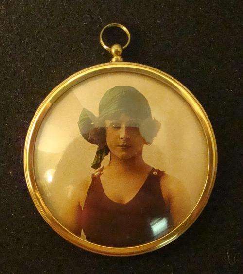 A dome-glassed, brass frame with a Victorian Bathing Belle picture