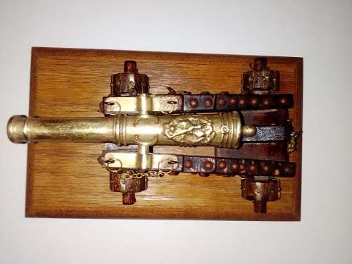 A Brass Canon with crest on Barrel, mounted on a wooden plinth with 4 feet.