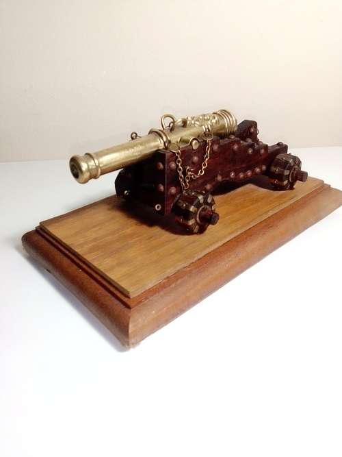 A Brass Canon with crest on Barrel, mounted on a wooden plinth with 4 feet.