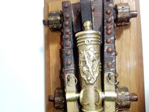 A Brass Canon with crest on Barrel, mounted on a wooden plinth with 4 feet.