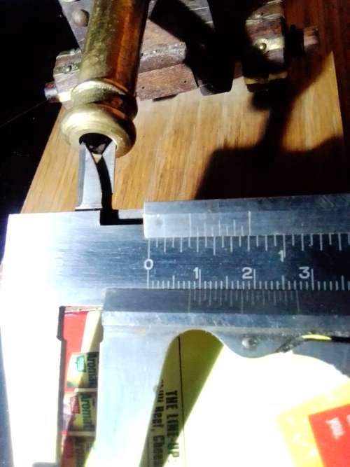 A Brass Canon with crest on Barrel, mounted on a wooden plinth with 4 feet.
