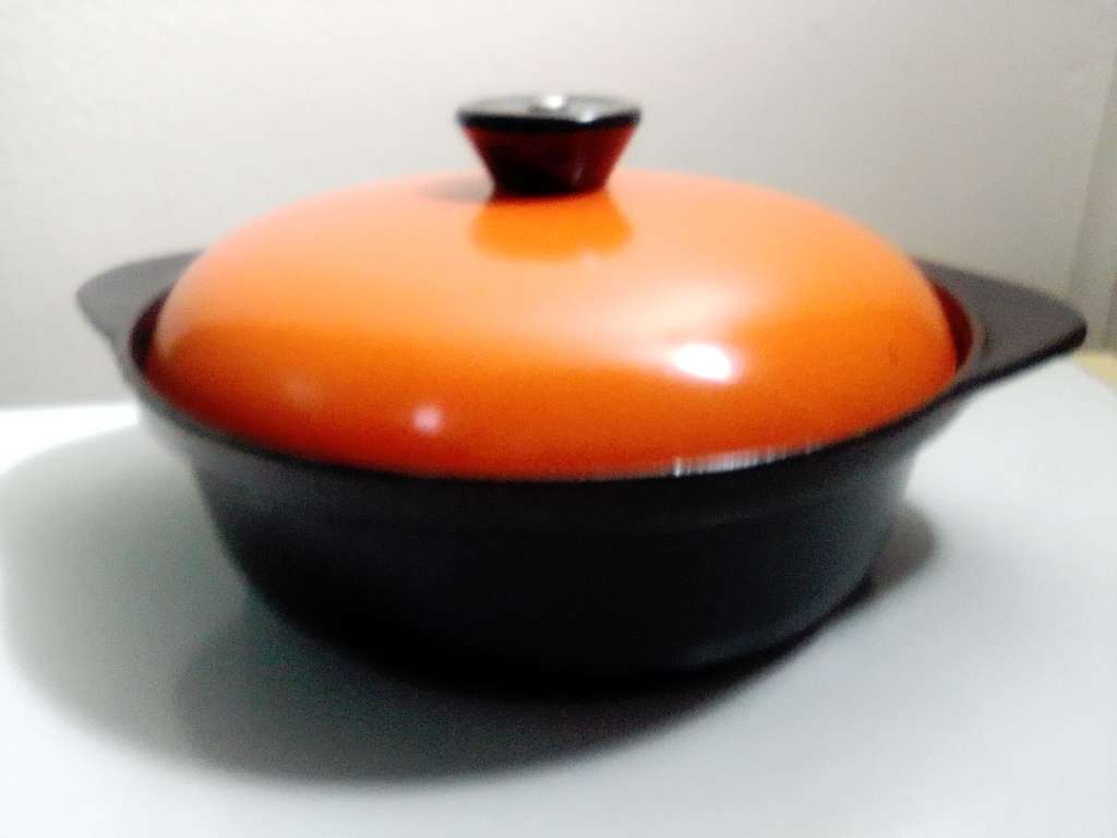 A well-used and in pristine orde, vintage Cookwell orange enameled lidded cast iron cooking pot No8.
