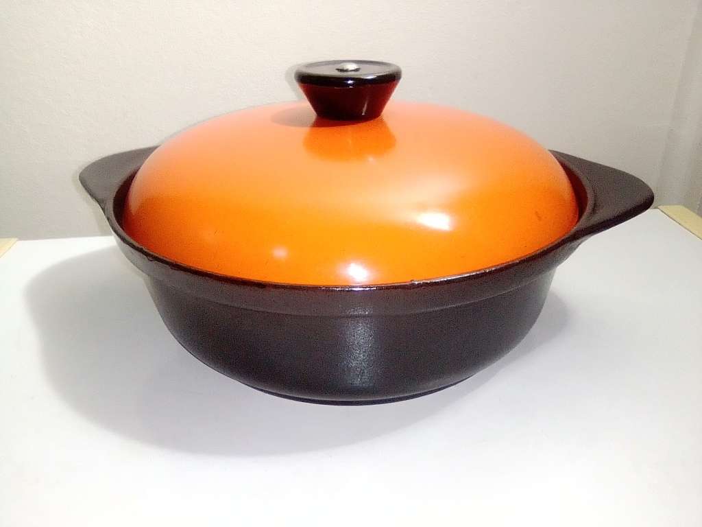 A well-used and in pristine orde, vintage Cookwell orange enameled lidded cast iron cooking pot No8.
