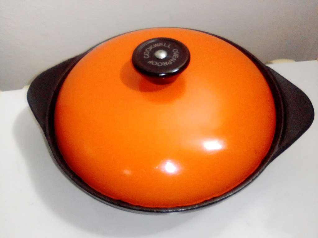 A well-used and in pristine orde, vintage Cookwell orange enameled lidded cast iron cooking pot No8.