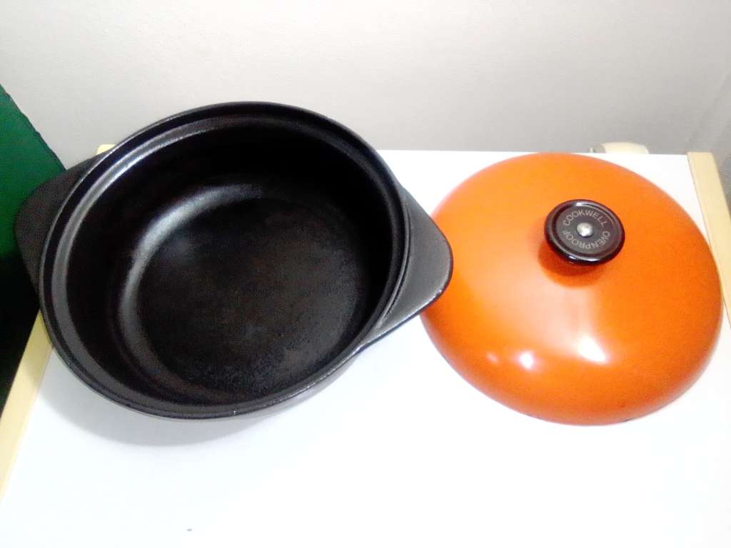A well-used and in pristine orde, vintage Cookwell orange enameled lidded cast iron cooking pot No8.