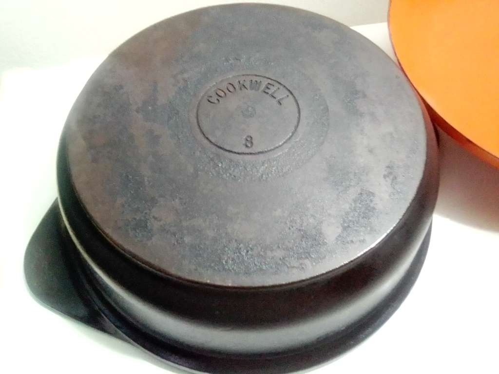 A well-used and in pristine orde, vintage Cookwell orange enameled lidded cast iron cooking pot No8.
