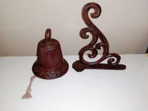 A Old school front door Cast Iron Bell hanging on a nice scrolled bracket.